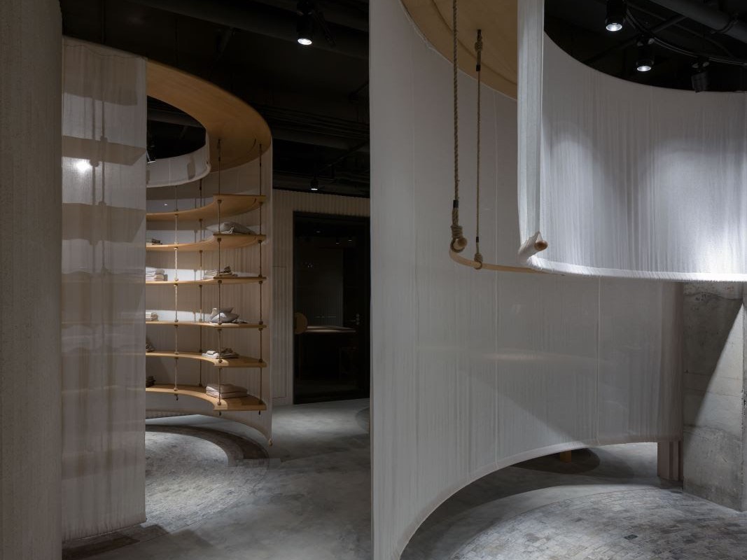 Flowy Curtains Meet Heavy Bricks in Jisifang Store Interior