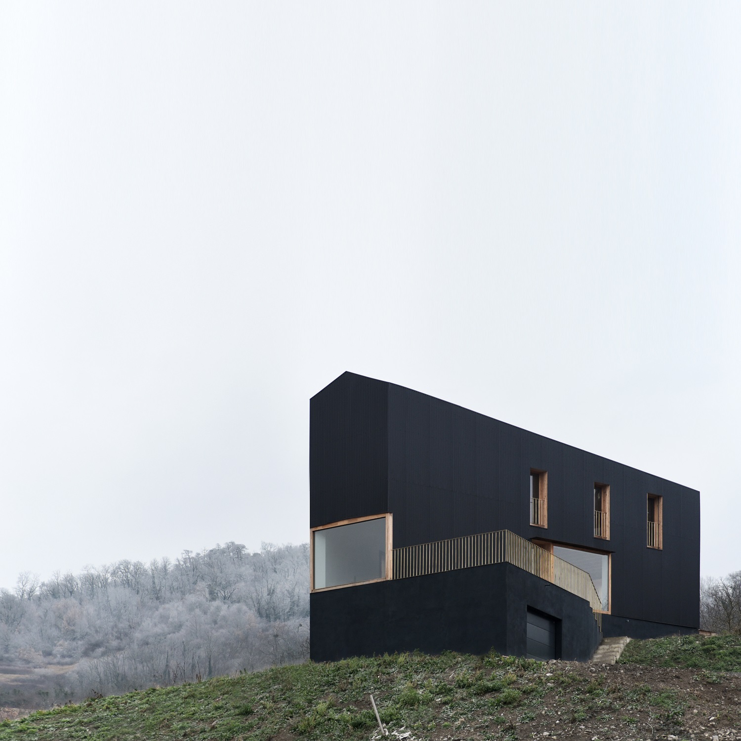 Detached House by RÃ©cita Architecture stands on the edge of the slopes of Puy-de-Mur, a distance from the surrounding rural environment