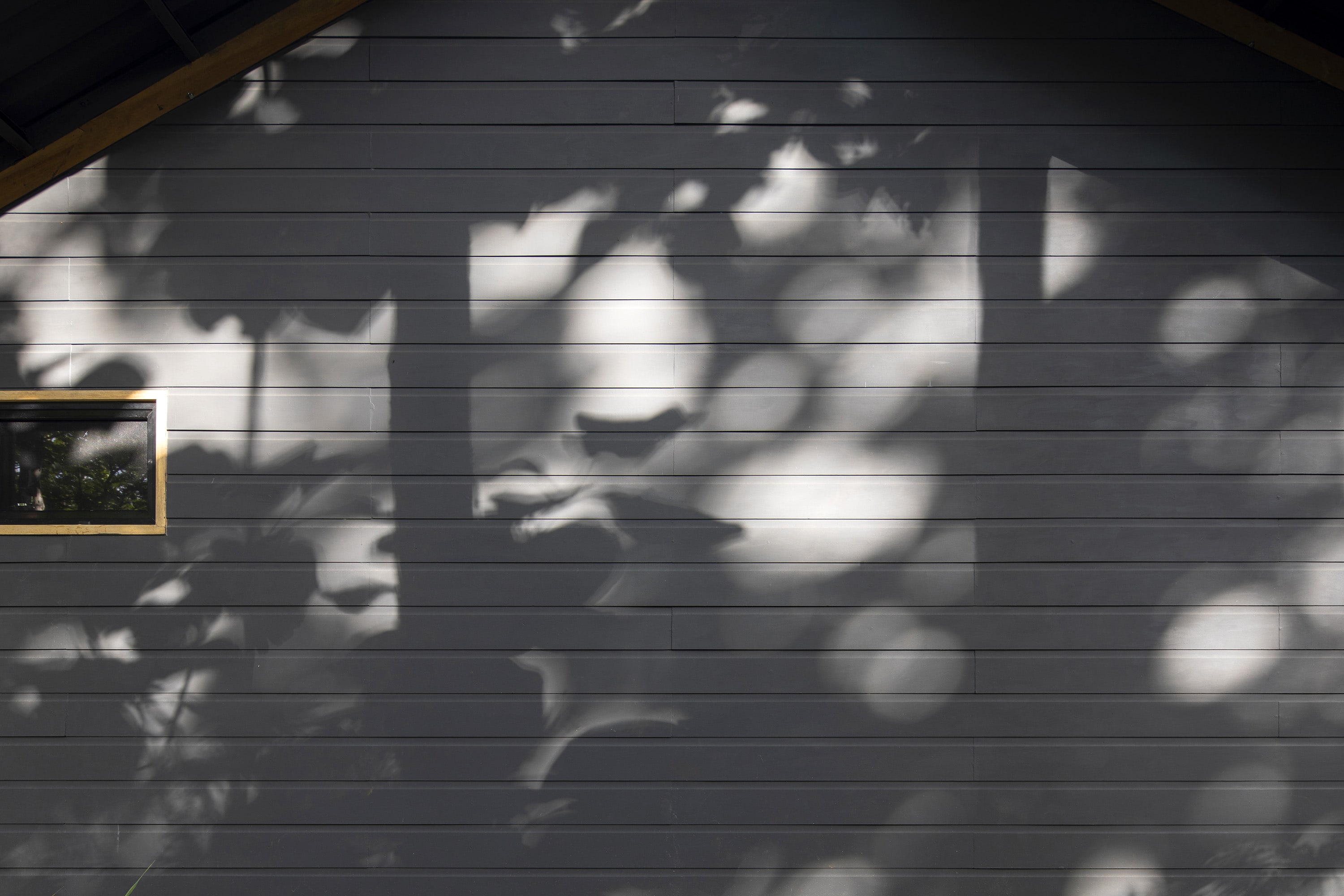 Wooden details on the faÃ§ade of the house, which are already given a dark gray tint