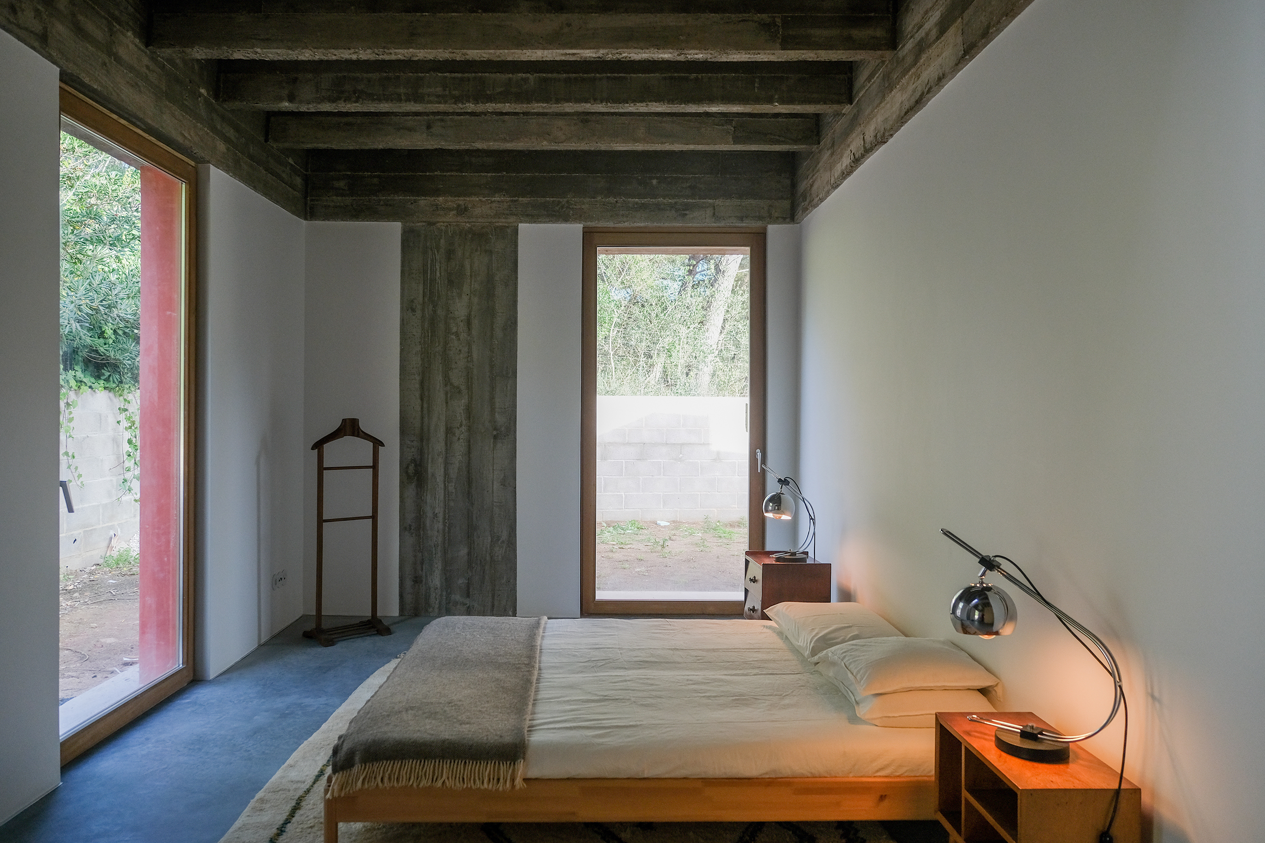 The interior of the bedroom is defined by a set of secondary beams