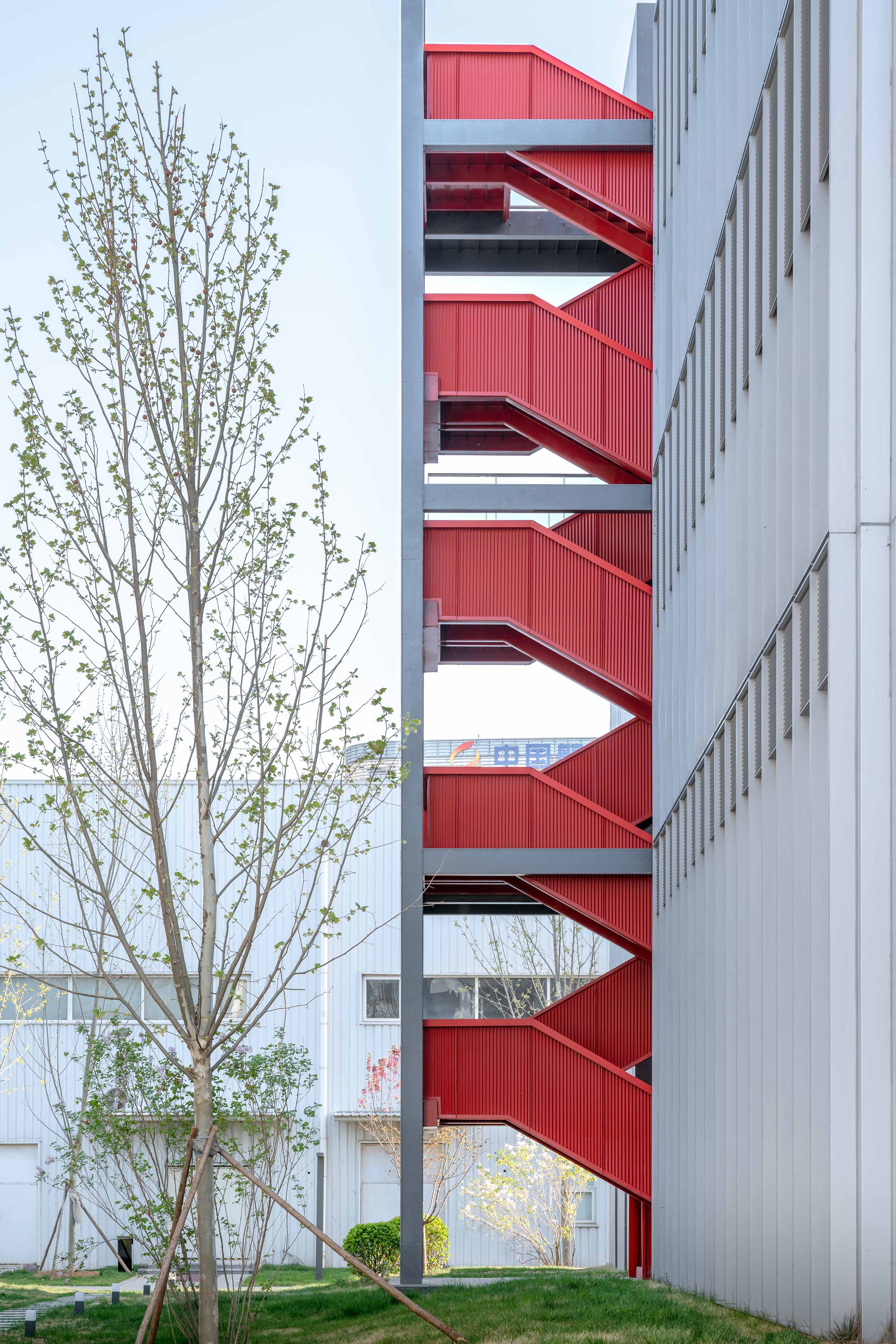 The bright red exterior staircase on the west side of the building