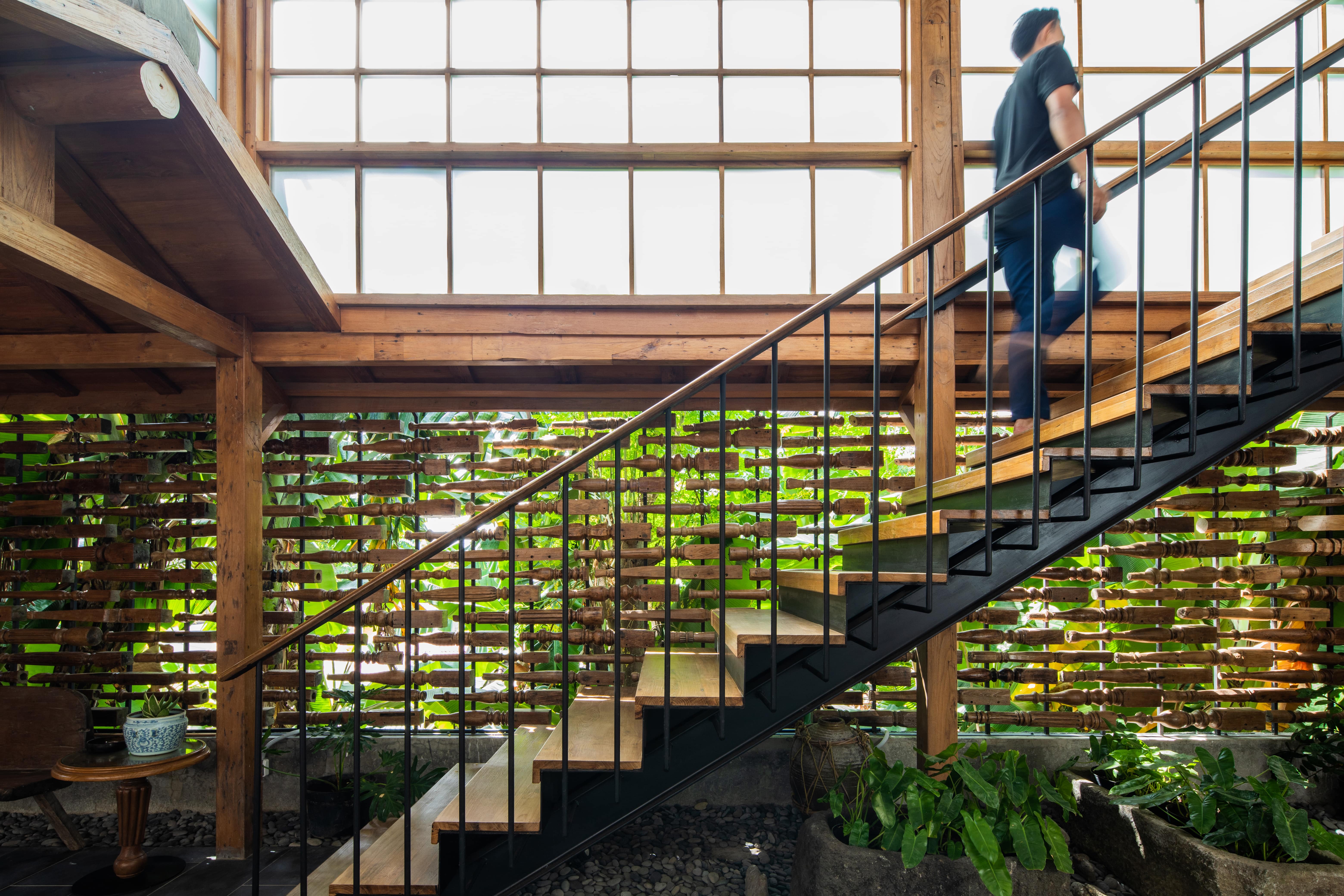 The stairwell area of the apartment has a screen made of recycled table legs as the facade