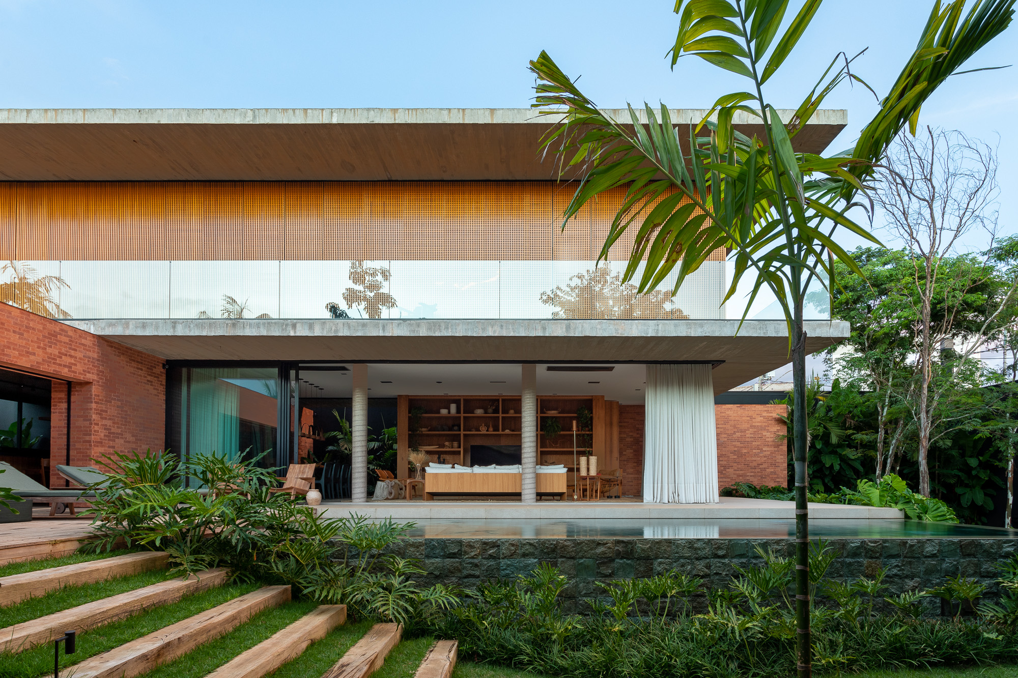 The transparency of the openings on the ground floor of the house promotes the integration of indoor and outdoor spaces