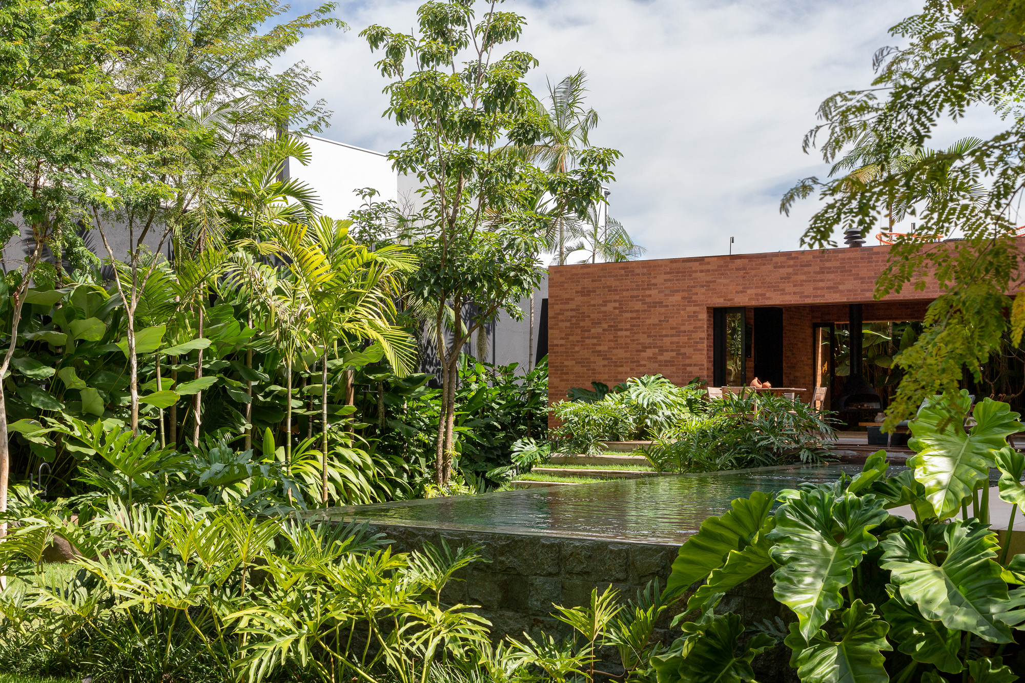 A garden complete with an infinity edge pool becomes the orientation of the house