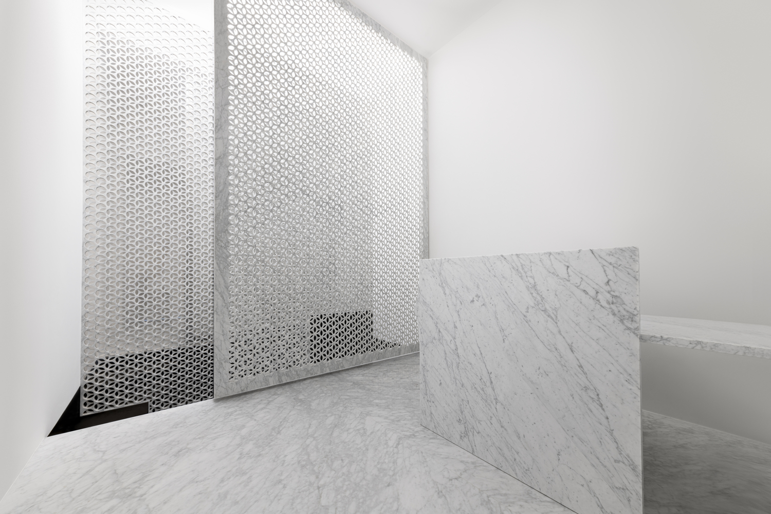 A perforated marble screen hides the staircase to the basement