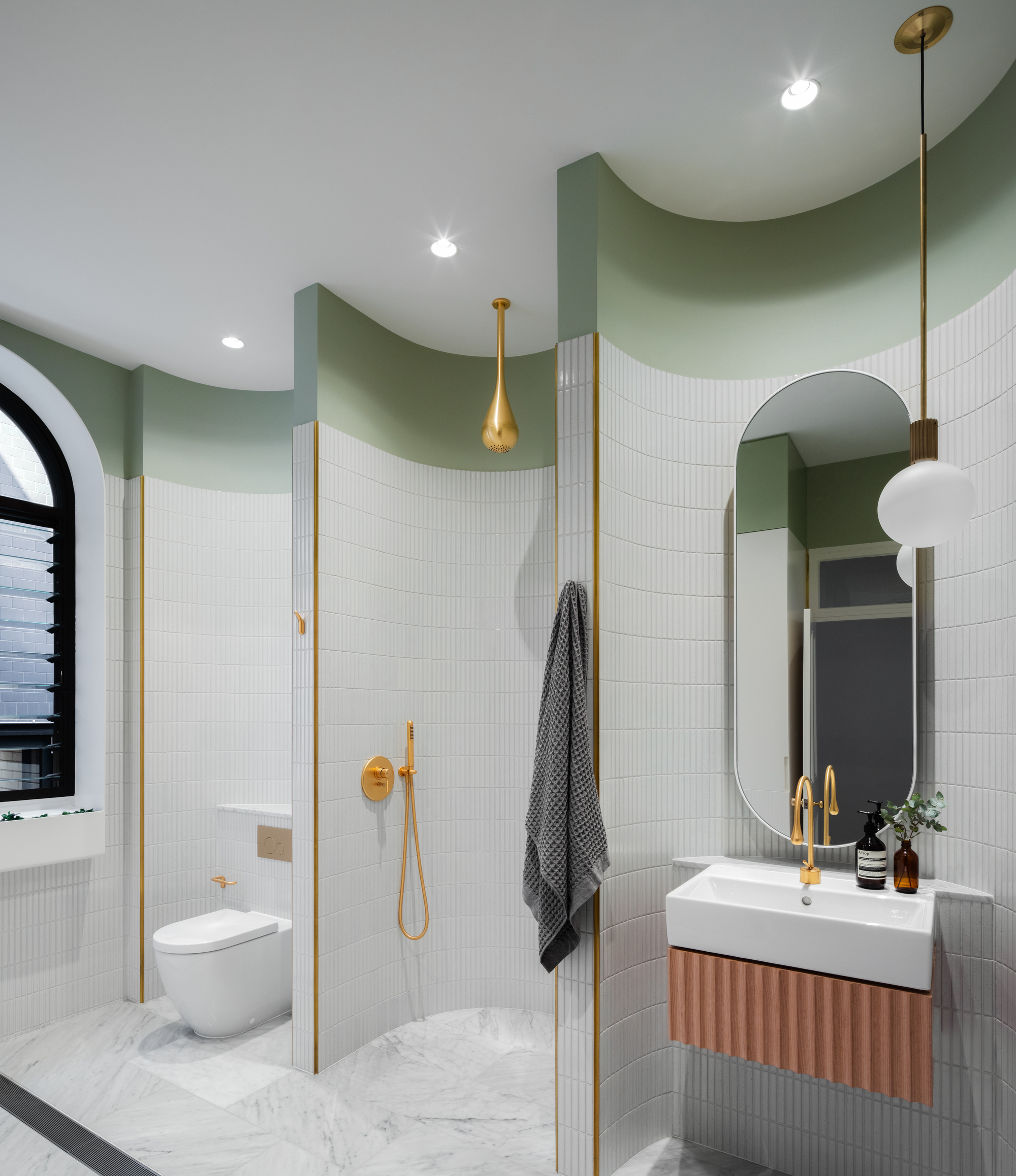 A round chandelier with gold-colored aluminum is also presented in the bathroom