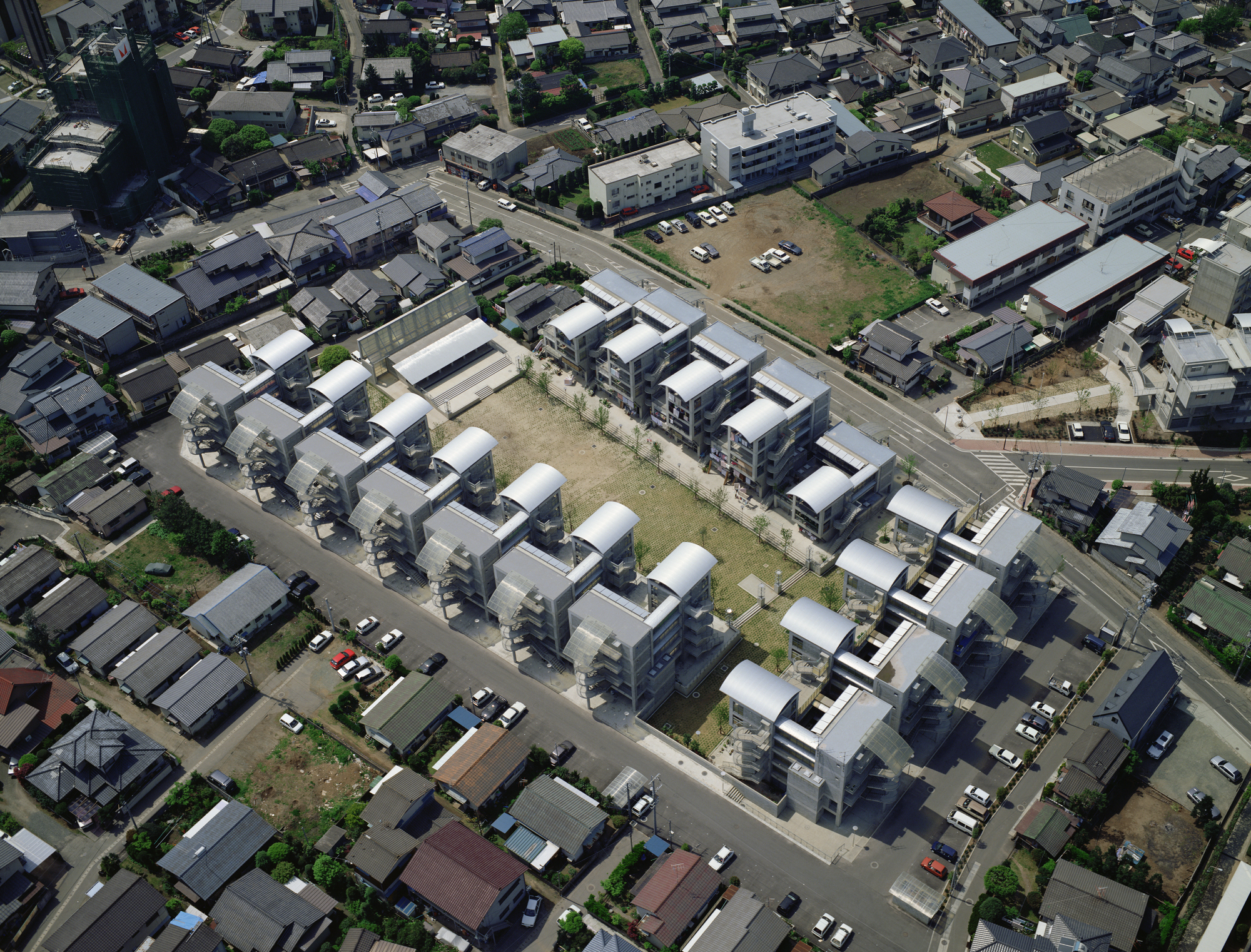 Sixteen clusters of Hotakubo Housing arranged around a courtyard