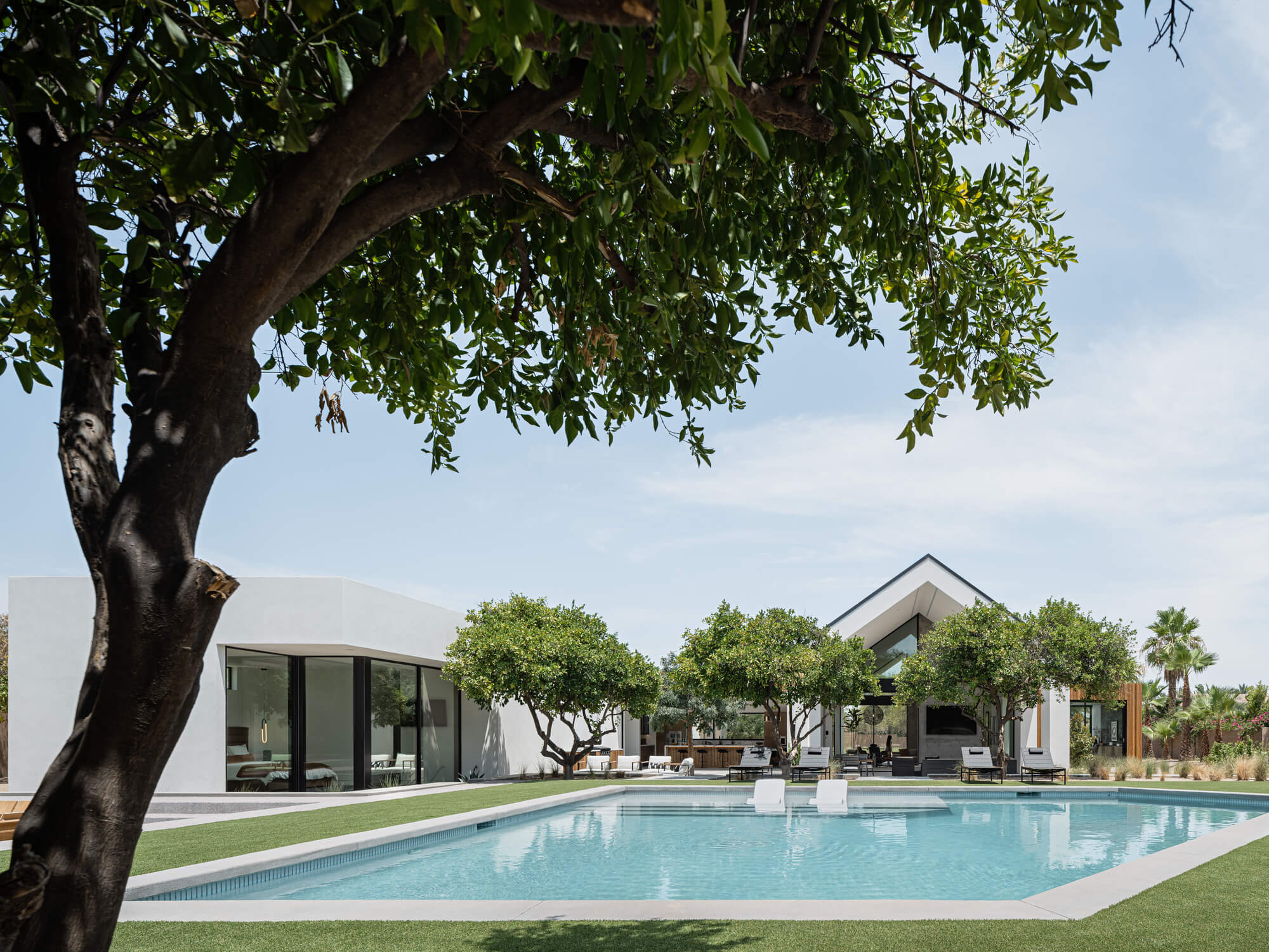 the communal area with glass-door access that leads to a covered patio, pool, hot tub, and sunken fire pit outside