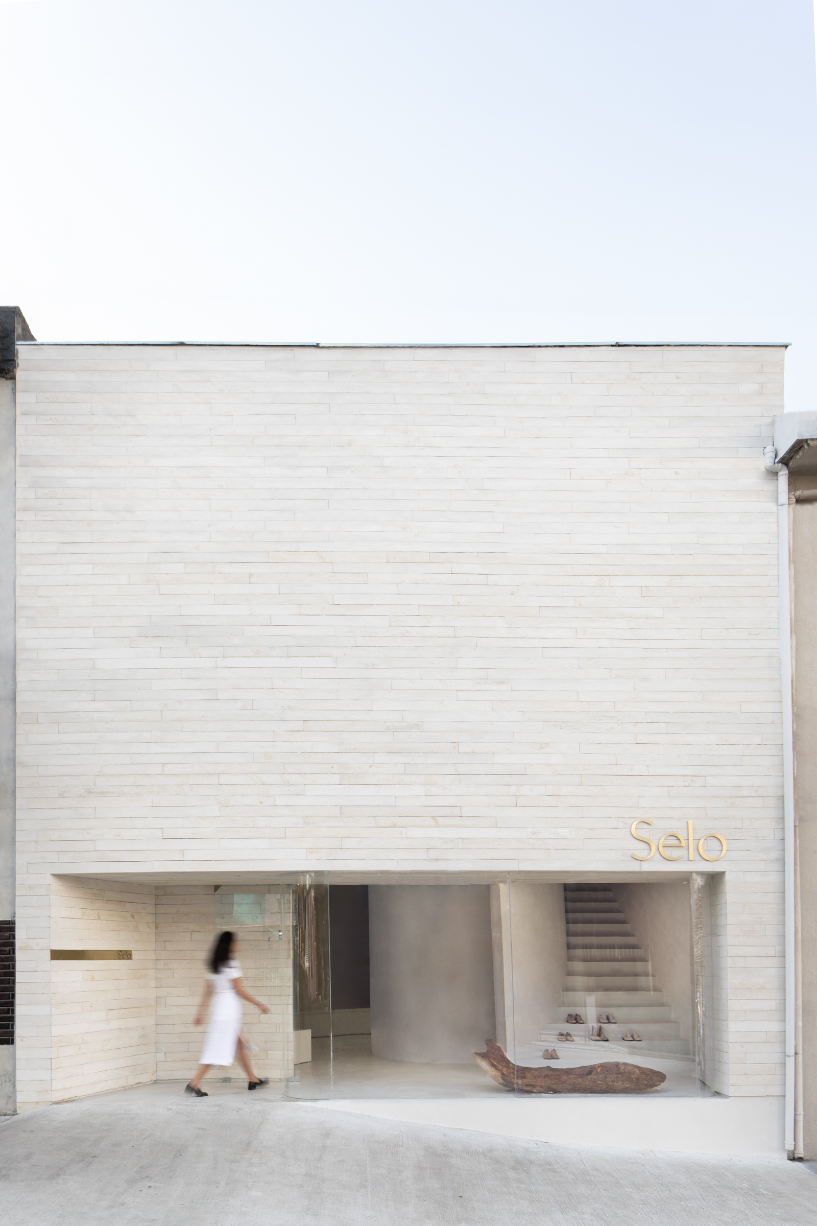 The front view of the Selo Store is dominated by the natural colors of concrete and cement