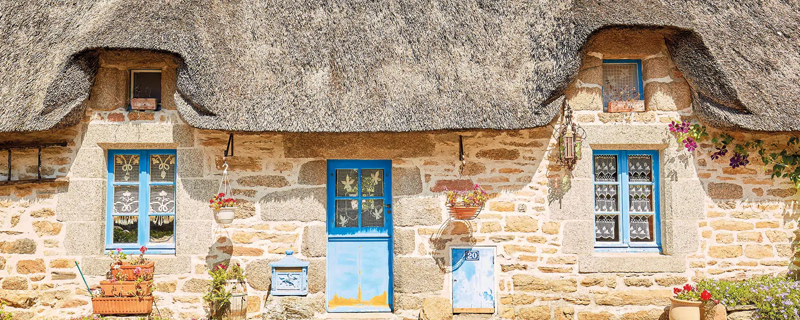 Thatched houses in KerascoÃ«t's small openings with blue shutters