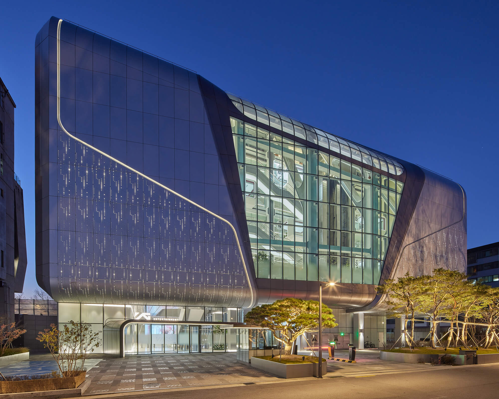 the exterior is designed with a central glass section flanked by a metal panel finishing like a shell